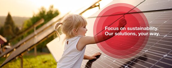 A photograph of a little girl who plays in the nature surrounded by solar panels. 